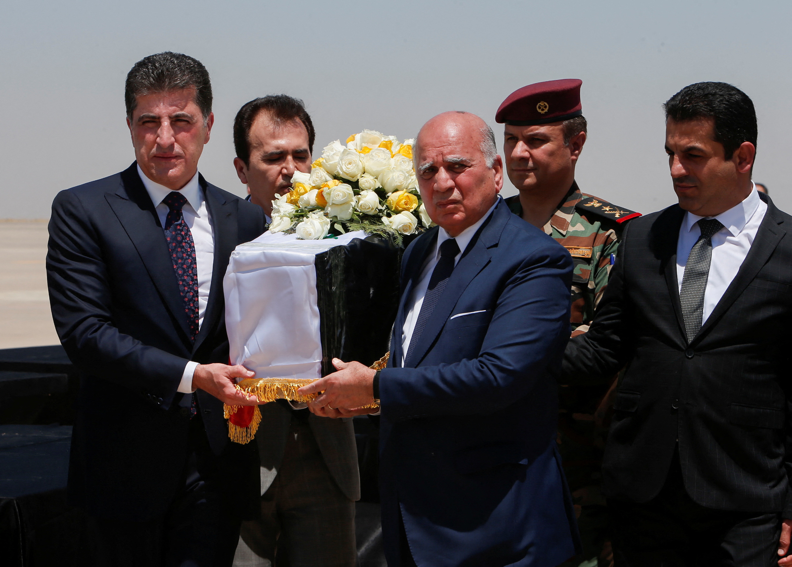 President of the Kurdistan region in Iraq Nechirvan Barzani carries the coffin of an Iraqi who was killed in an attack on a mountain resort in Iraq's northern province Dohuk, during funeral ceremony, at Erbil International Airport, in Erbil, Iraq, July 21, 2022. REUTERS / Azad Lashkari