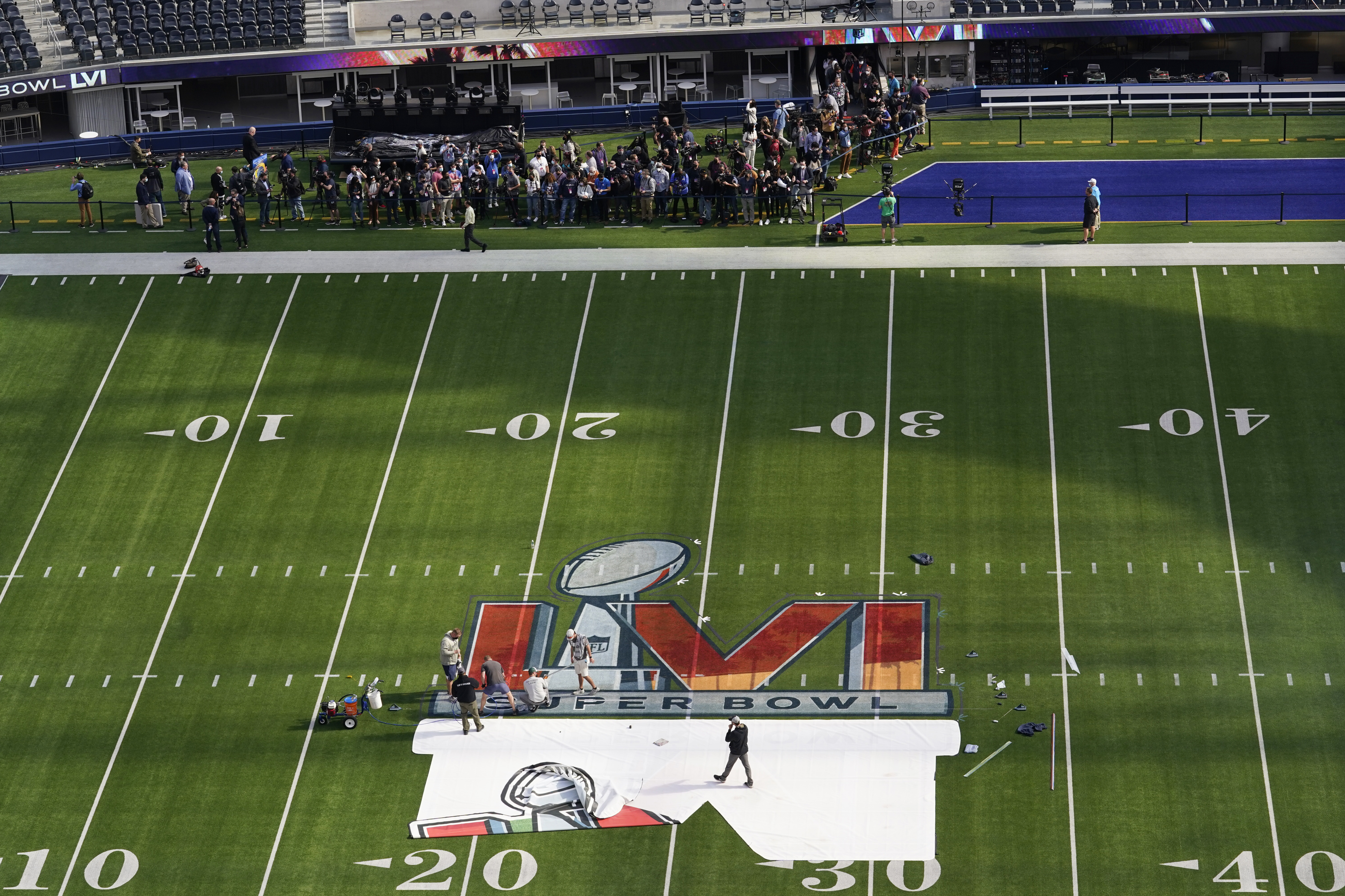 01 February 2022, US, Inglewood: Workers paint the Super Bowl LVI logo on  the field at SoFi Stadium. The Los Angeles Rams and Cincinnati Bengals will  meet here on Feb. 13, 2022 (