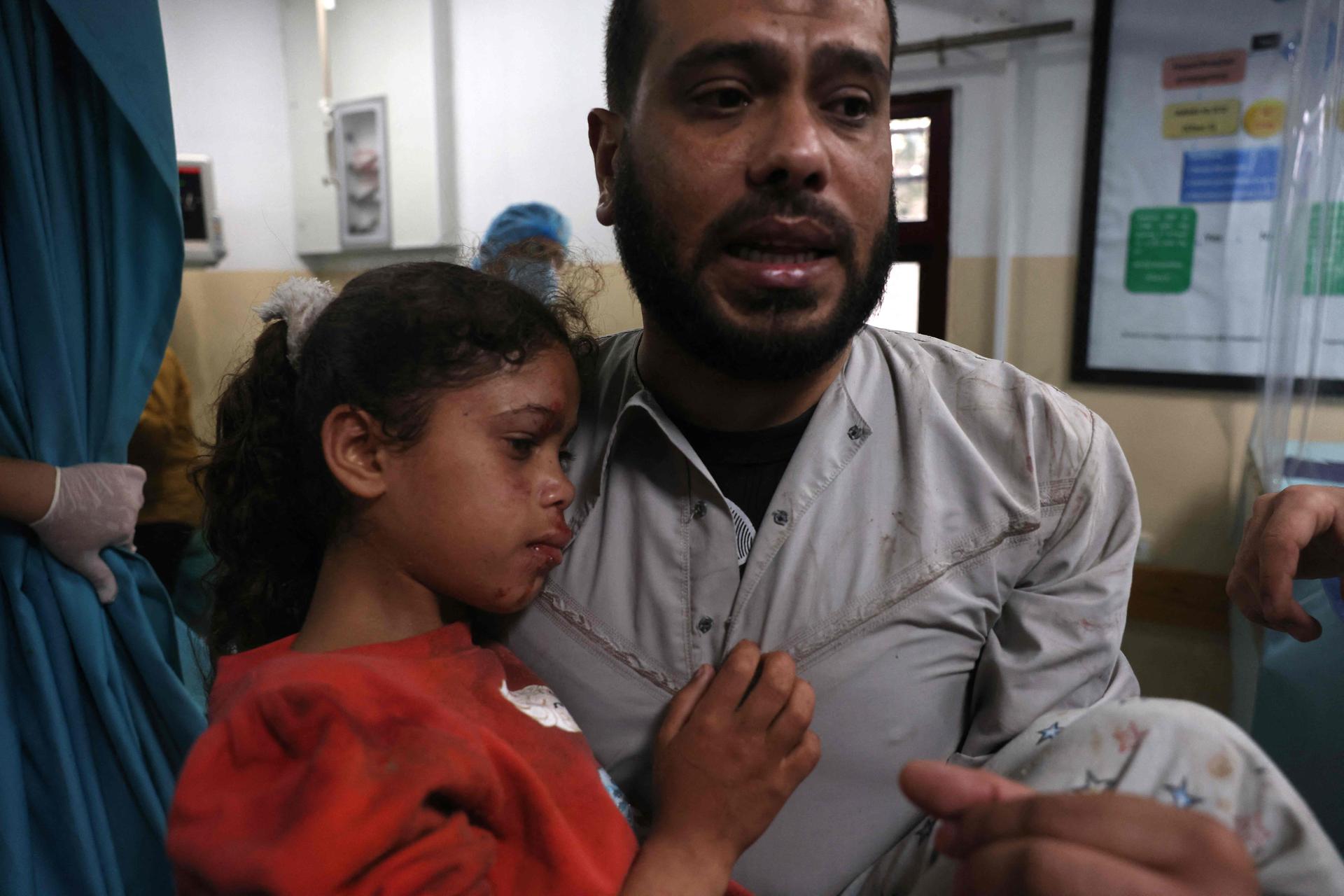A Palestinian man carries a wounded girl at a hospital in the northern Gaza Strip. Nine people were killed amid air raids in the Gaza Strip, local authorities said. It was unclear whether the deaths were caused by the air strikes. Israel said it bombed Hamas targets in Gaza in response to rocket fire directed towards Israel. AFP