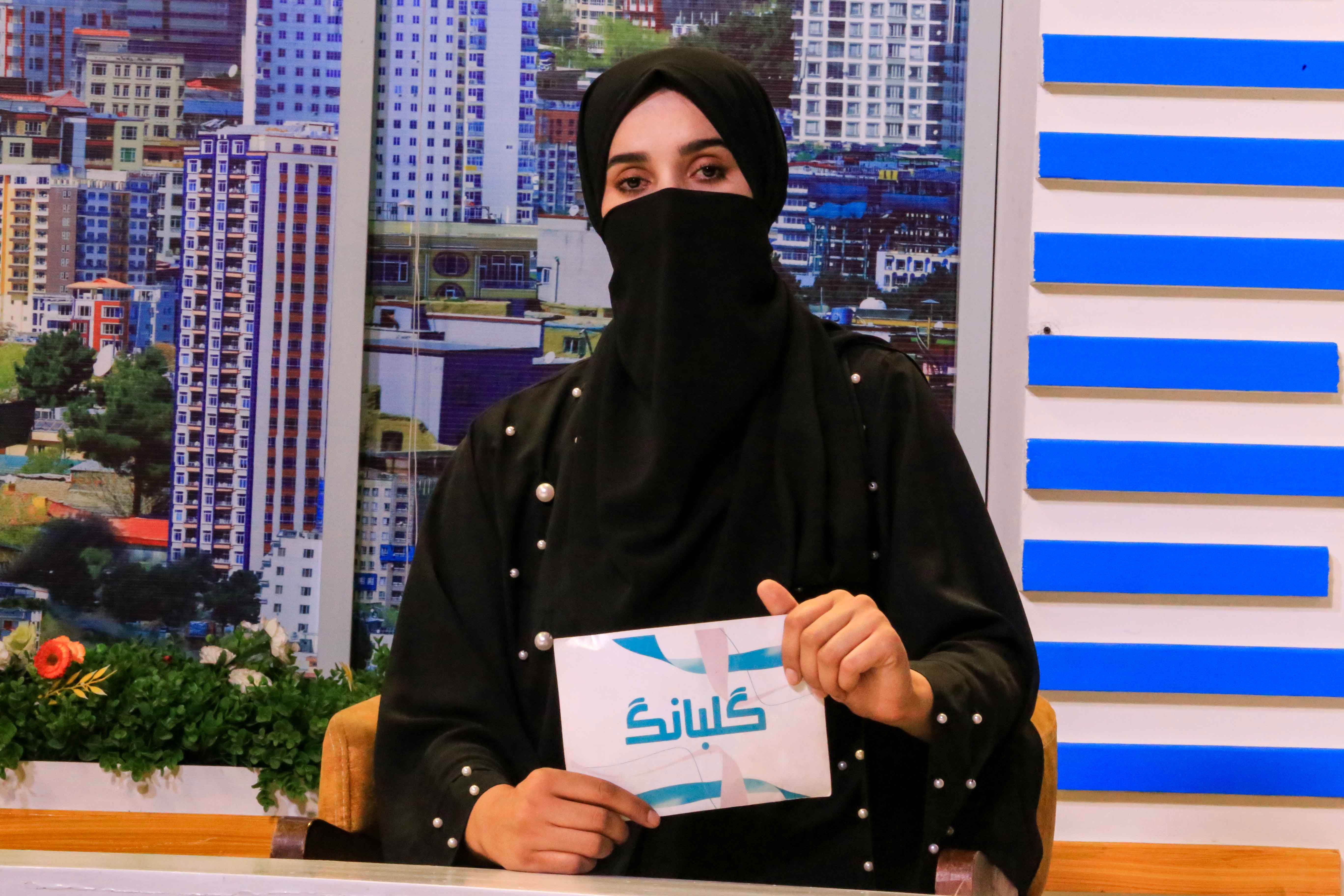 Shgofe, an Afghan newscaster, presents a programme on private channel 1TV in Kabul. Female TV presenters and reporters in Afghanistan continue to appear with their faces covered to comply with a mandate issued by the Taliban. EPA